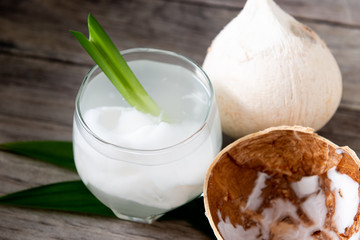 Fresh coconut juice in a glass with coconut white meat isolated on white