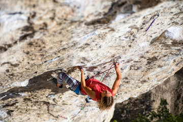 Climber overcomes challenging climbing route. A girl climbs a rock. Woman engaged in extreme sport....
