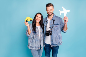 Portrait of lovely spouses holding paper card plane and taxi camera wearing denim jeans jackets...