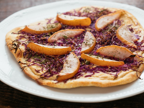 Traditional German flammkuchen (flatbread) with red cabbage and pears.