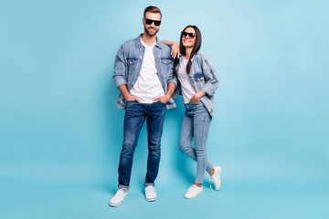 Full length photo of charming spouses looking with beaming smile wearing denim jeans eyeglasses...