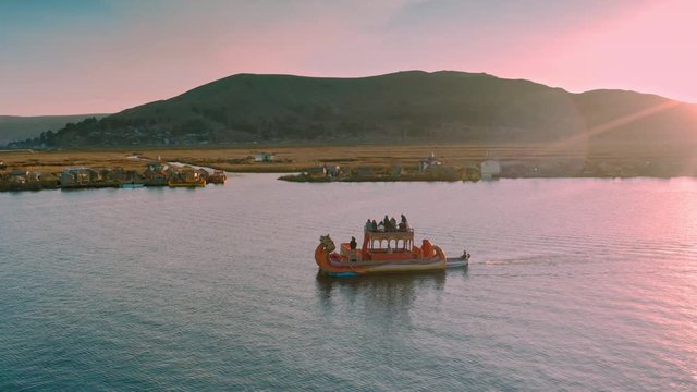 Following classic Uros Boat on Lake Titicaca at Sunset