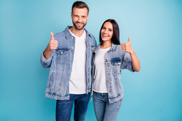 Fototapeta premium Portrait of pretty sweethearts hugging embracing smiling wearing denim jeans isolated over blue background