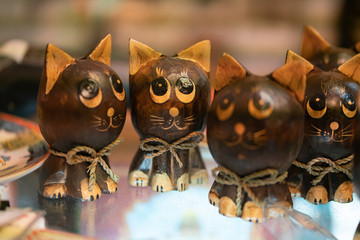 many brown cute wooden cats figurines on the glass table