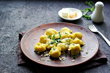 Pumpkin dumplings or gnocchi with parmesan cheese, butter and parsley on a brown clay plate. Harvest pumpkins. Thanksgiving Day. Selective focus. Italian food.
