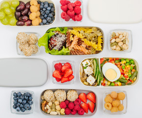 Pattern of plastic lunch boxes filled with healthy food on white background