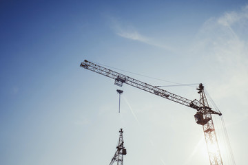 under construction, crane silhouette against blue sky