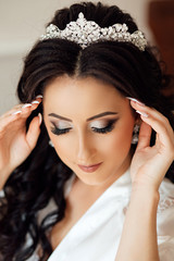 Obraz premium Beautiful bride portrait wedding makeup and hairstyle, girl in diamonds tiara, jewelry model, fashion bride gorgeous beauty. Close up portrait of Beautiful bride lowered her eyes down, shows makeup.