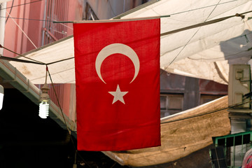 Turkish Flag hanging on a rope in an old street bazaar between shading tents in Old Town, Istanbul.