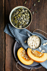 Pumpkin seeds in ceramic bowl, decorated with pumpkin slices