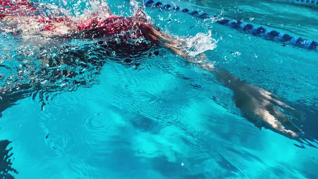 Athletic Young woman professional triathlon swimmer practicing in morning pool