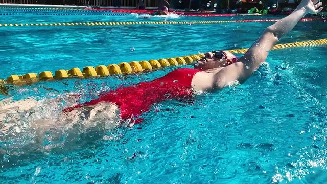 Backstroke training of Professional Swimmer in slow motion. woman athlete swim her practice in pool outdoor