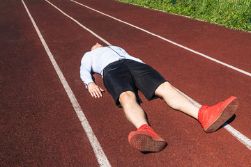 The young athlete is exhausted from training in hot weather. The athlete is on the treadmill sports...