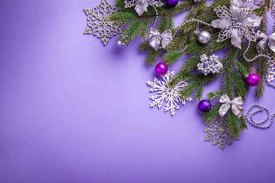 Purple Christmas and New Year background with decorated fir tree and toys. Space