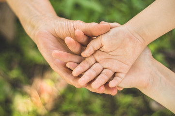 Childs hand and old hand grandmother. Concept idea of love family protecting children and elderly people grandmother friendship togetherness relationship Two generation.