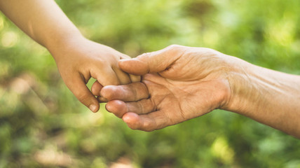 Childs hand and old hand grandmother. Concept idea of love family protecting children and elderly people grandmother friendship togetherness relationship Two generation.