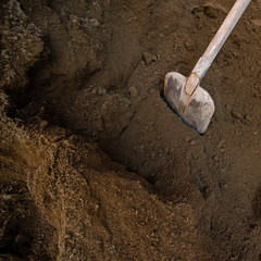 Square background with shovel in a pile of industrial soil