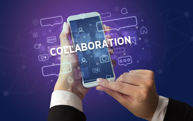 Female hand typing on smartphone with COLLABORATION inscription, social media concept
