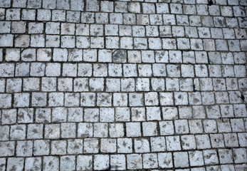 old pedestrian walkway on the street paved with stones