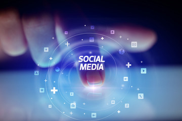 Finger touching tablet with social media icons and SOCIAL MEDIA