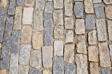 old pedestrian walkway on the street paved with stones
