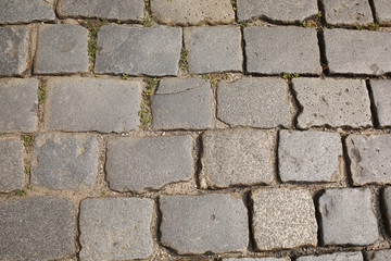 old pedestrian walkway on the street paved with stones