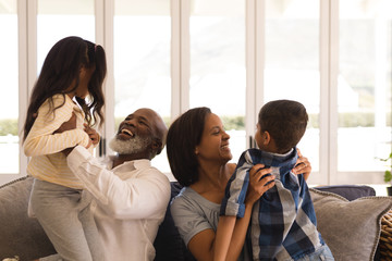 Multi-generation family having fun in living room