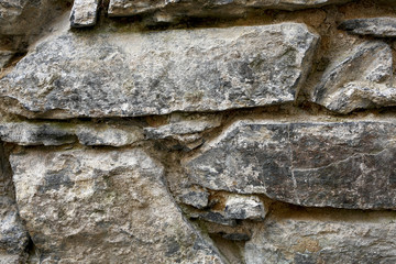 real stone wall of ancient stones of gray-beige color