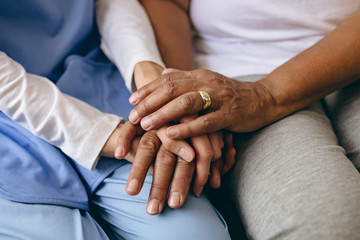 Female doctor holding hand of senior patient 