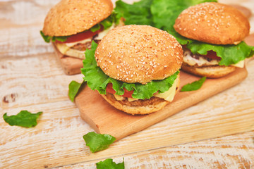 Craft beef burger  on wooden table on light background. Street food, fast food. Homemade juicy burgers with cheese and  on the wooden table. Copy space.