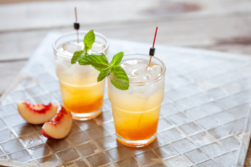 Peach cocktail with mint on grey background