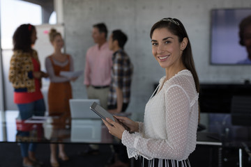 Beautiful female executive using digital tablet in office