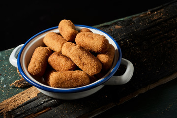 spanish croquettes on a rustic wooden table.