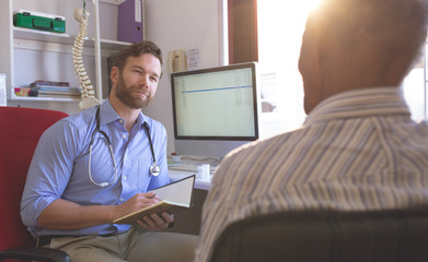 Fototapeta premium Male doctor and senior man interacting with each other in clinic