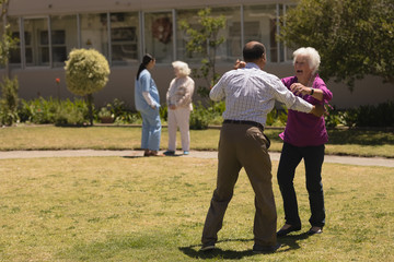 Senior couple dancing together in garden 