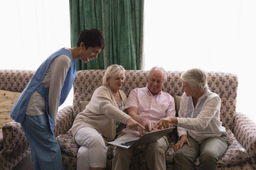 Senior people using laptop in living room