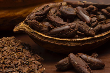 Open cocoa with toasted beans close in wood background