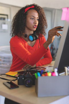 Female graphic designer working on desktop pc at desk 