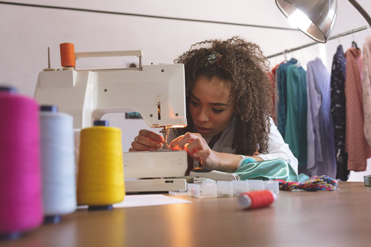 Female fashion designer working with sewing machine - Powered by Adobe