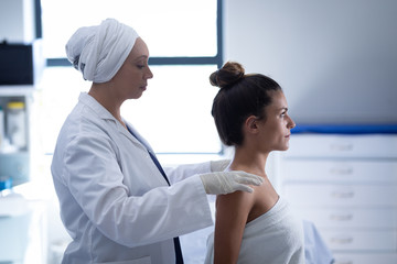 Obraz premium Mature female doctor giving massage to the woman in clinic