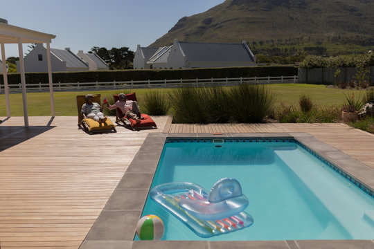 Senior couple having cocktail drink in the backyard of home