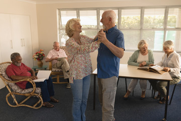 Active senior couple dancing at nursing home