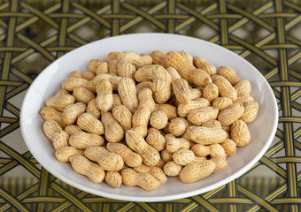 A plate of fried peanuts in a white porcelain plate