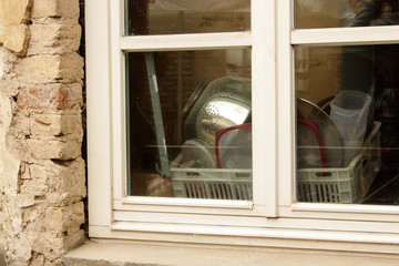 Drying kitchen utensils in old kitchen window with reflection from outside