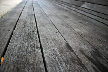Dark gray wooden plank bench textured surface background in perspective
