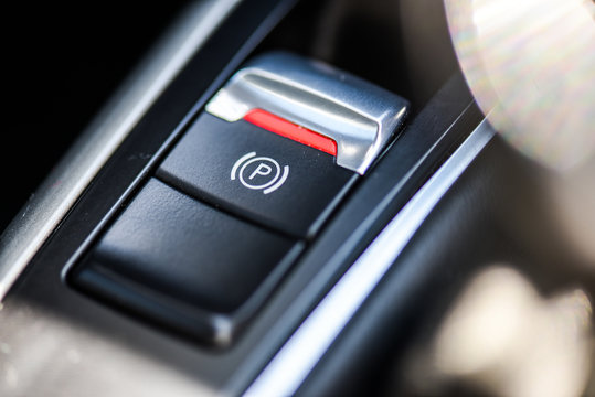 Finger pressing the electronic parking brake button