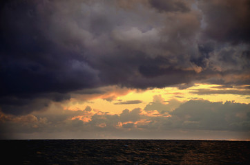 Seashore sky orange tones clouds and sea waves beautiful nature bright sunset