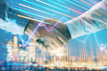 Double exposure of financial chart on cityscape background with two businessmen handshake. Concept of financial analysis and investment opportunities