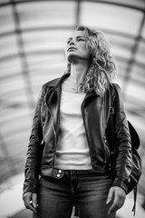 a girl in a leather jacket and jeans with freckles and loose hair