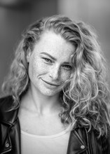 a girl in a leather jacket and jeans with freckles and loose hair